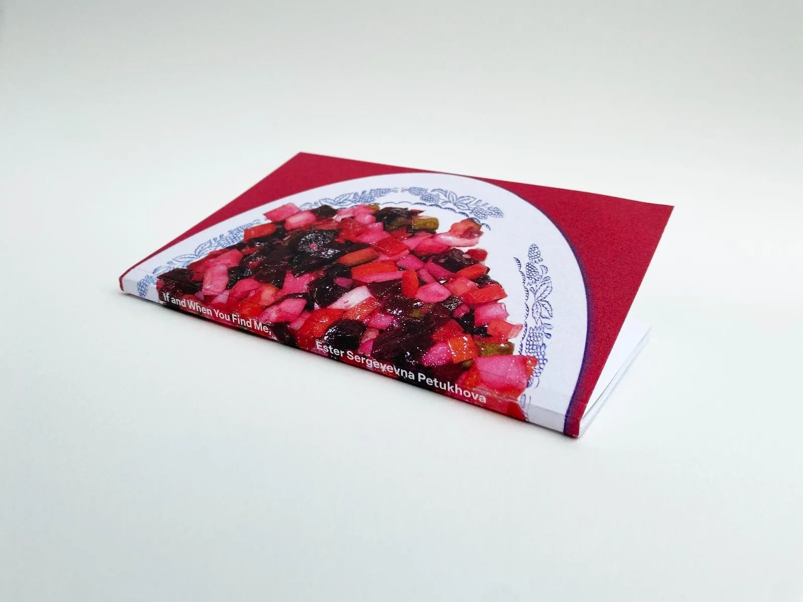 Photo of a book. The cover art is a photo of a blue and white decorated plate with an assortment of chopped red fruits/vegetables. The dish is on a red surface. The book spine reads, "If and When You Find Me" and "Ester Sergeyevna Petukhova."