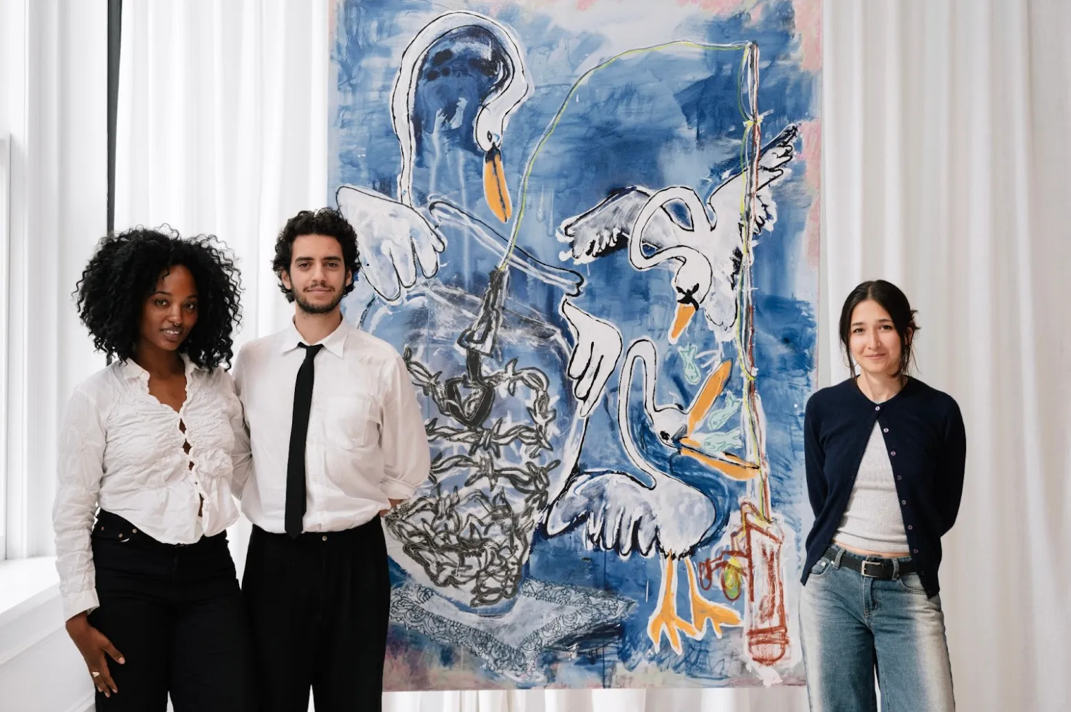Three people pose and face a camera around a large painting. The painting is made up of gesturally abstract swans against a brushstroked blue background. The painting also features other abstracted, gestural forms.