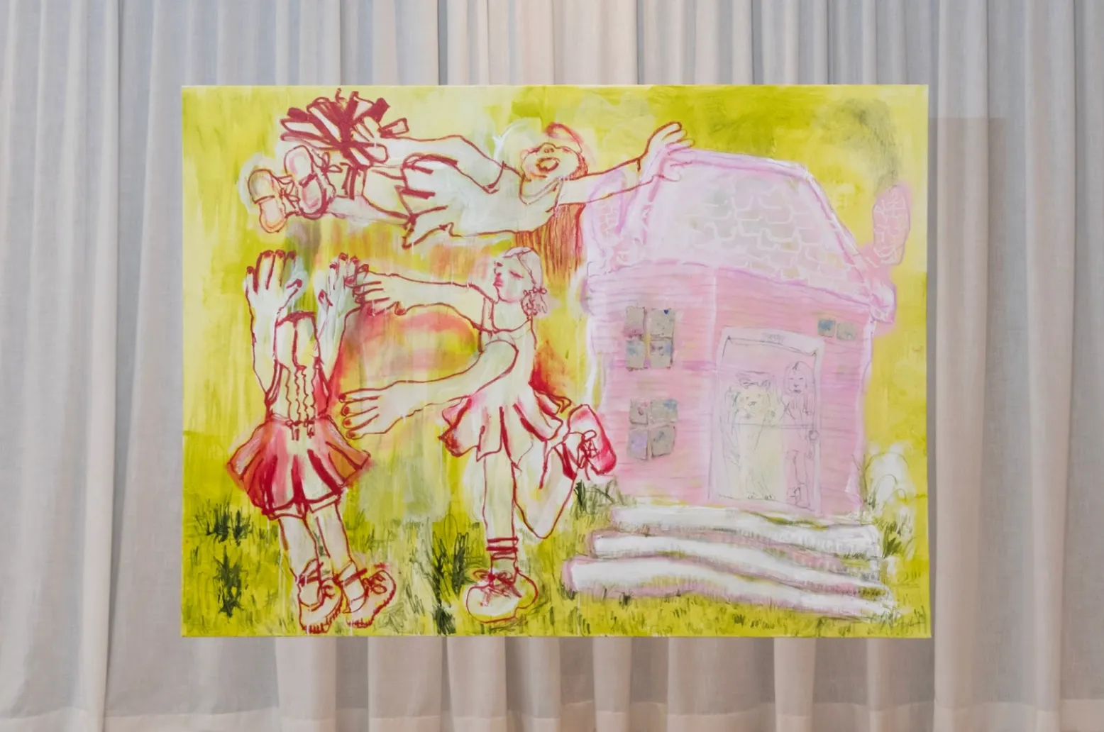 A painting, set against a curtained wall, depicts three abstracted, outlined figures engaging in play next to a non-proportional house. The palette is made up of red, pink, yellow, and chartreuse.
