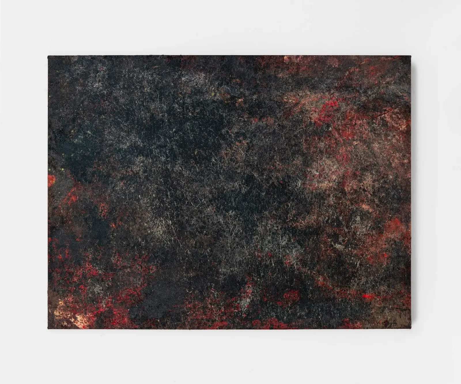 Dark, densely textured abstract painting with deep blacks and scattered red and brown tonal variations across the surface.