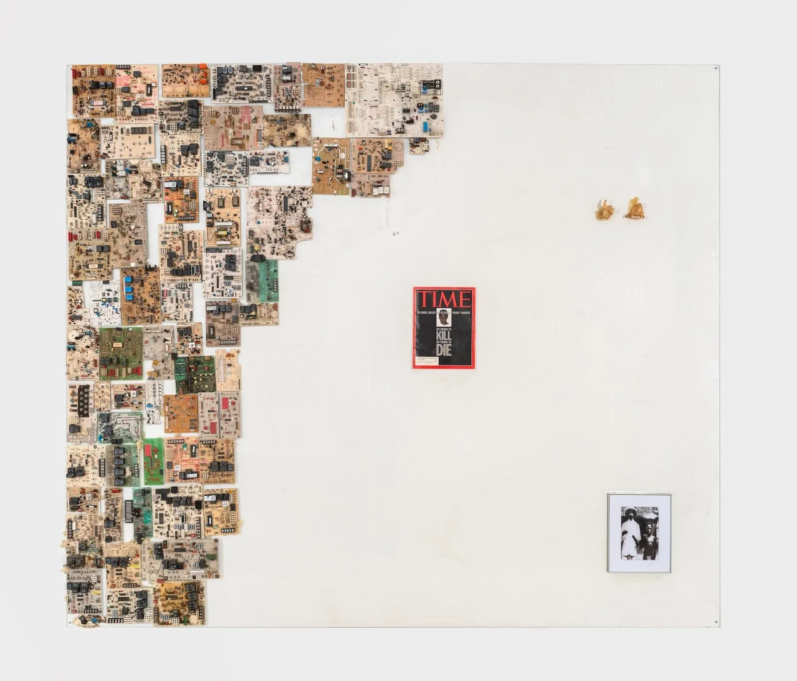 Large white panel partially covered along the left edge with an arrangement of small, varied circuit boards; a TIME magazine cover and a small black-and-white photograph appear on the otherwise blank right side.