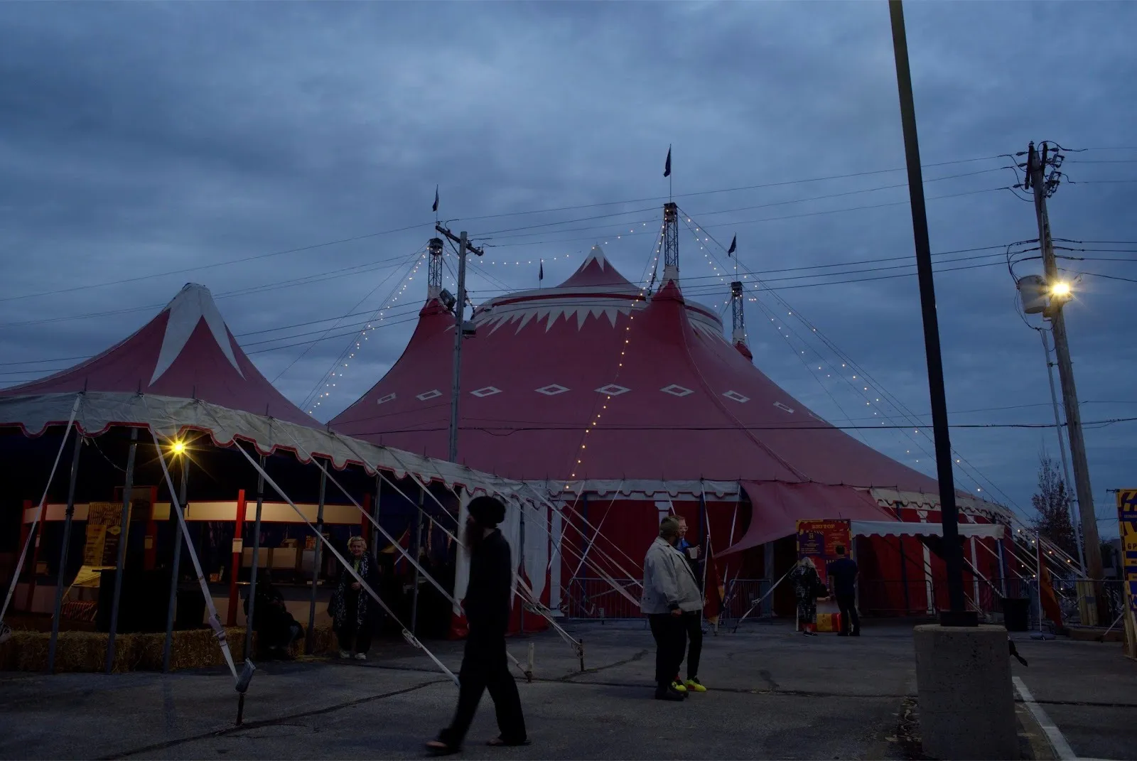 A large red tent with multiple spaces is erected in an outside space.