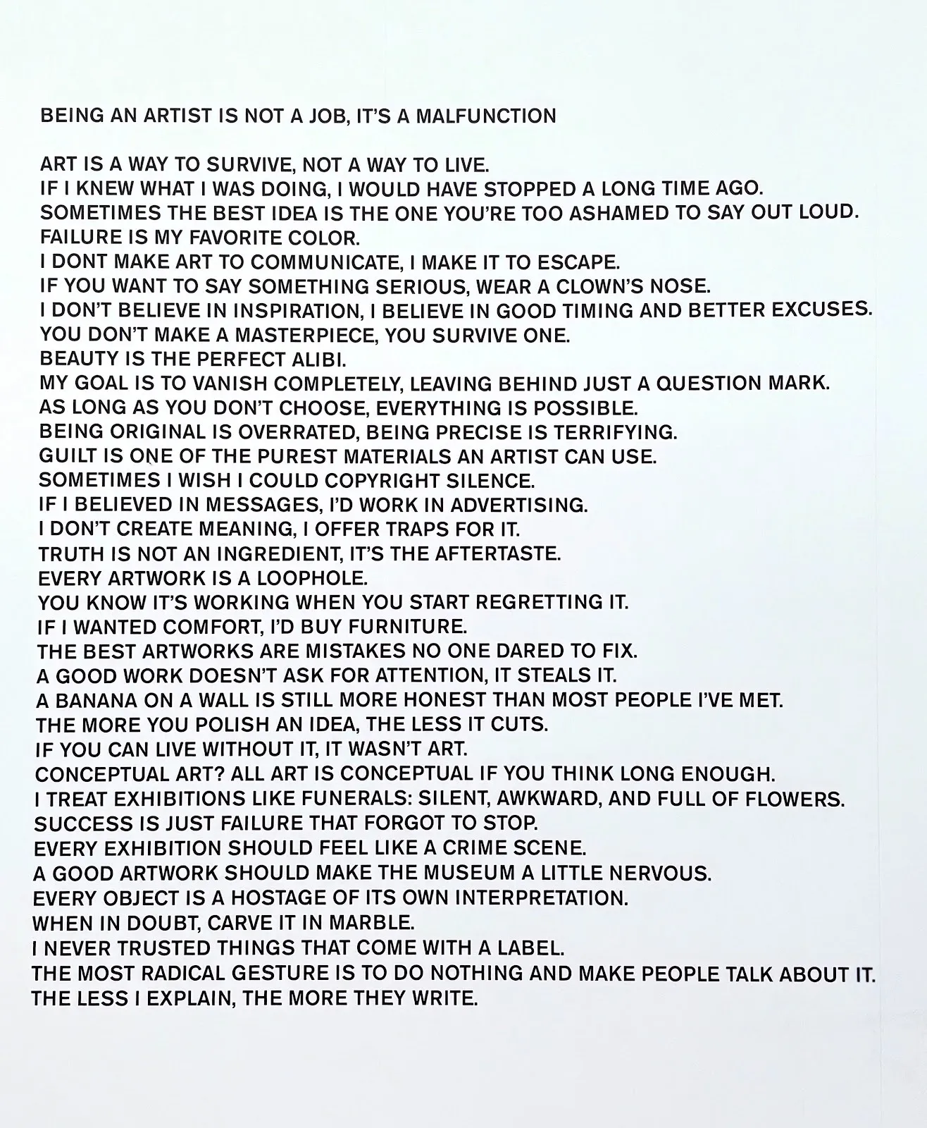 A white wall features lines of text statements. The title of the text reads "BEING AN ARTIST IS NOT A JOB, IT'S A MALFUNCTION."