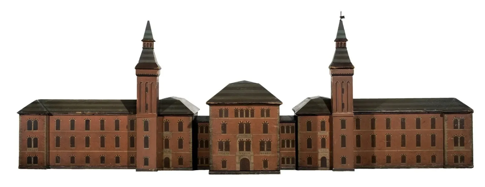 A miniature of a large, brown and grey building. The building is a hospital, featuring a central structure flanked by two pointed towers and adjoining wings.