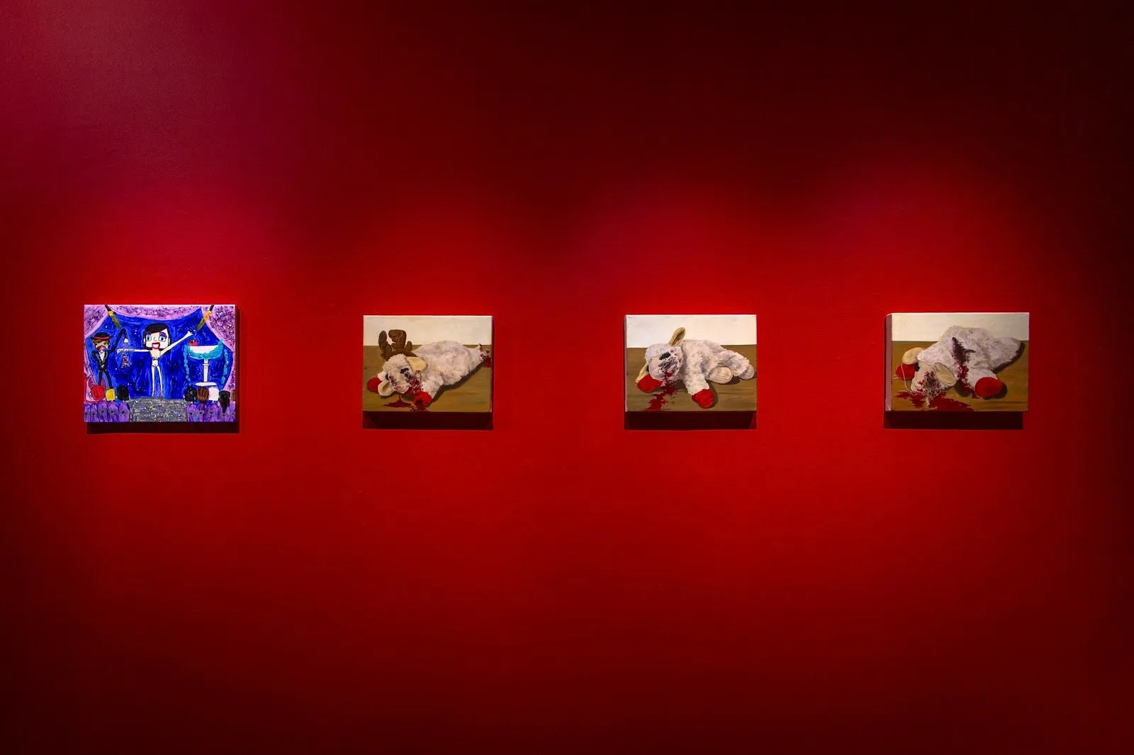 four similar-sized paintings hang in a row on a red gallery wall. One is rudimentary and colorful; the other three are thematically similar, all depicting different angles of a bloody lamb plushie.