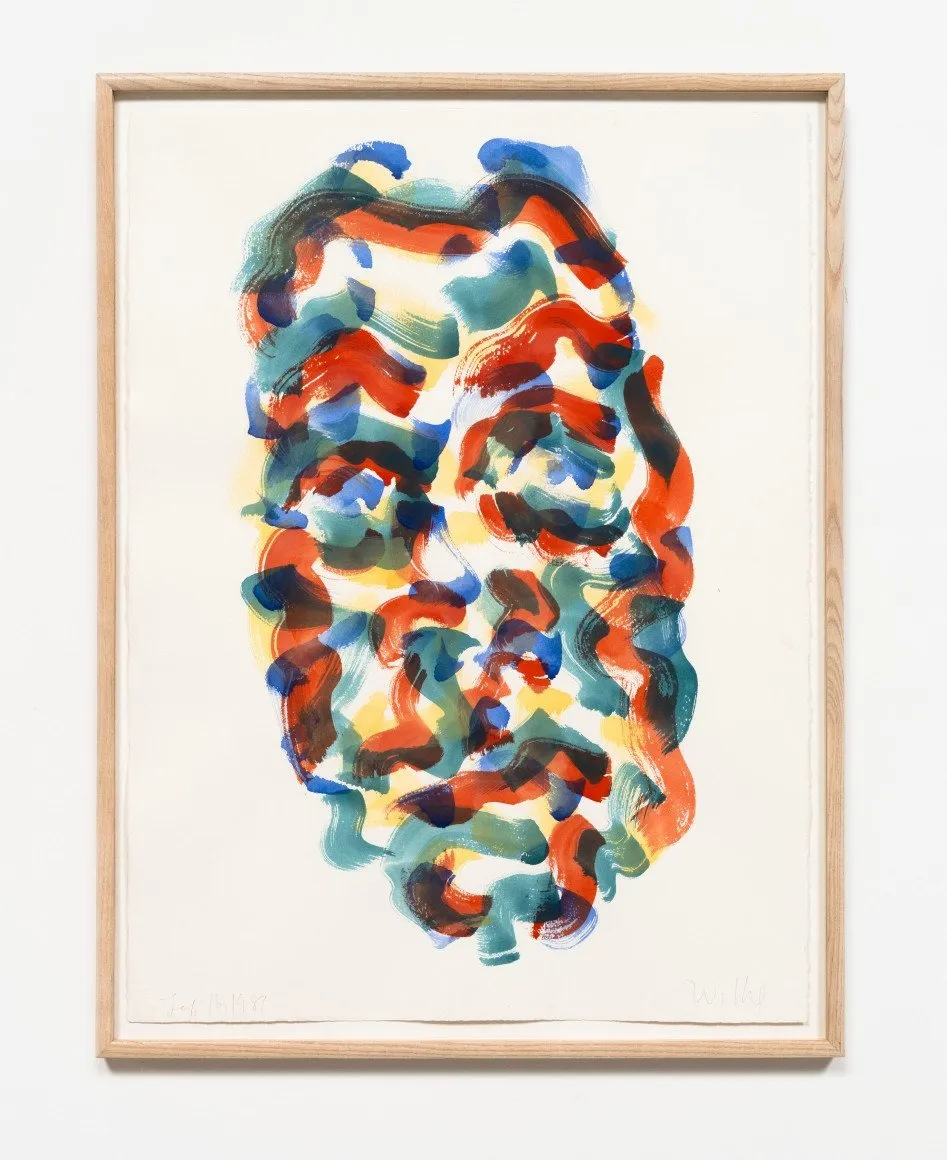 A thin wood-framed watercolor features an abstracted face, made from red, yellow, and blue squiggly brushstrokes overlaid on each other.