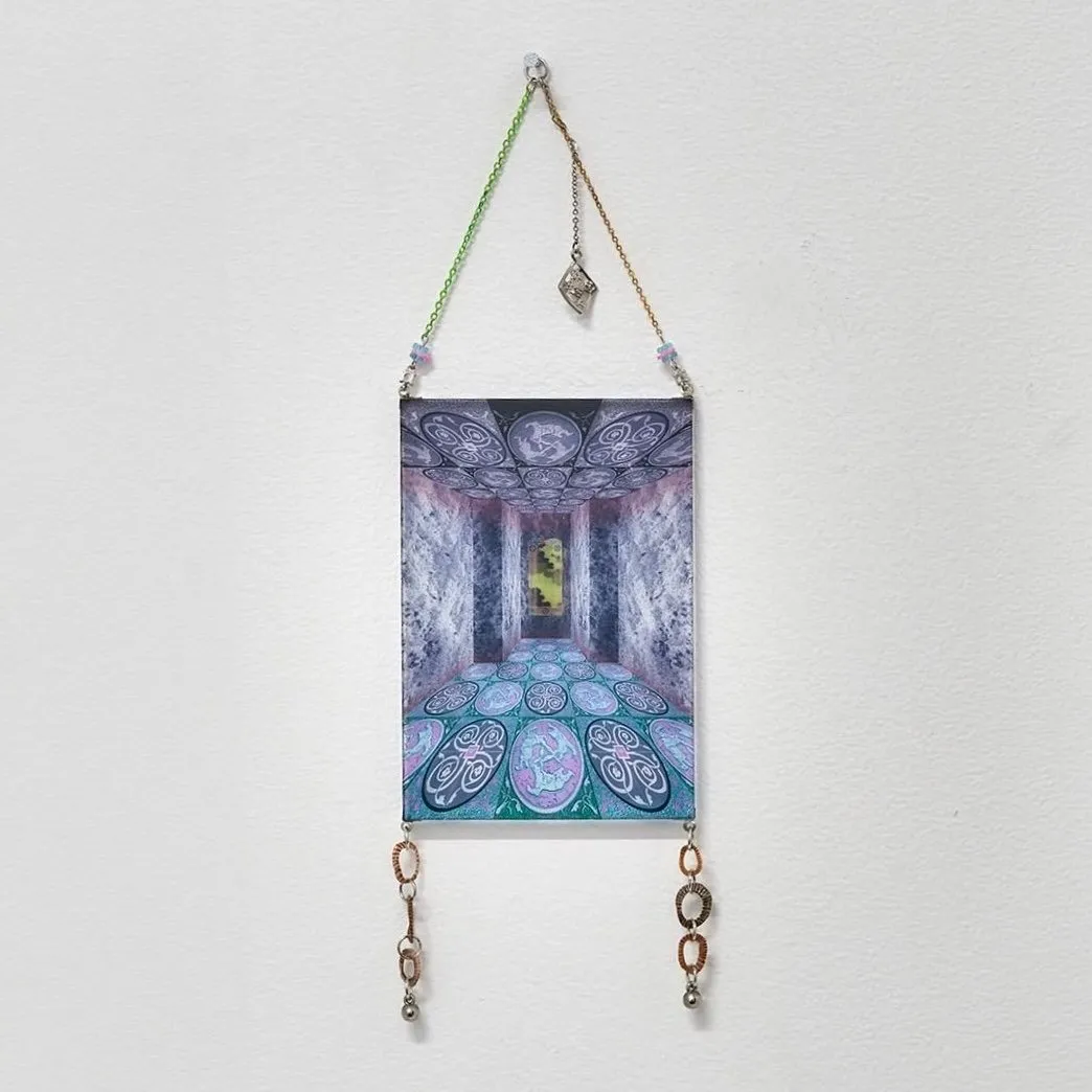 A 2D work hangs from the wall, suspended by green and yellow chains fastened to a nail. The main part of the work is an abstracted perspective of a tiled marble atrium-like room. Two ring-like charms linked together hang from the bottom.