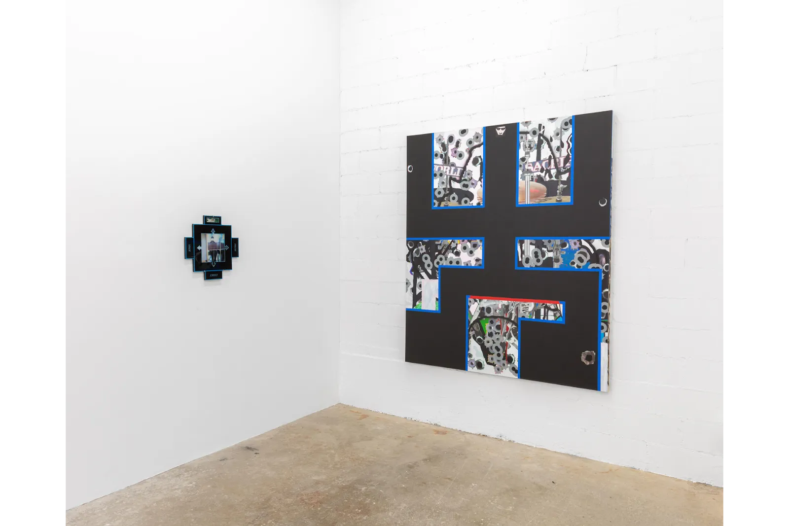 A white gallery room features two works on each wall. The left is a small, square-cross shape with a thick black interior lining. The right painting is a large, semi-geometric piece with thick black crossing lines and abstracted designs in between.