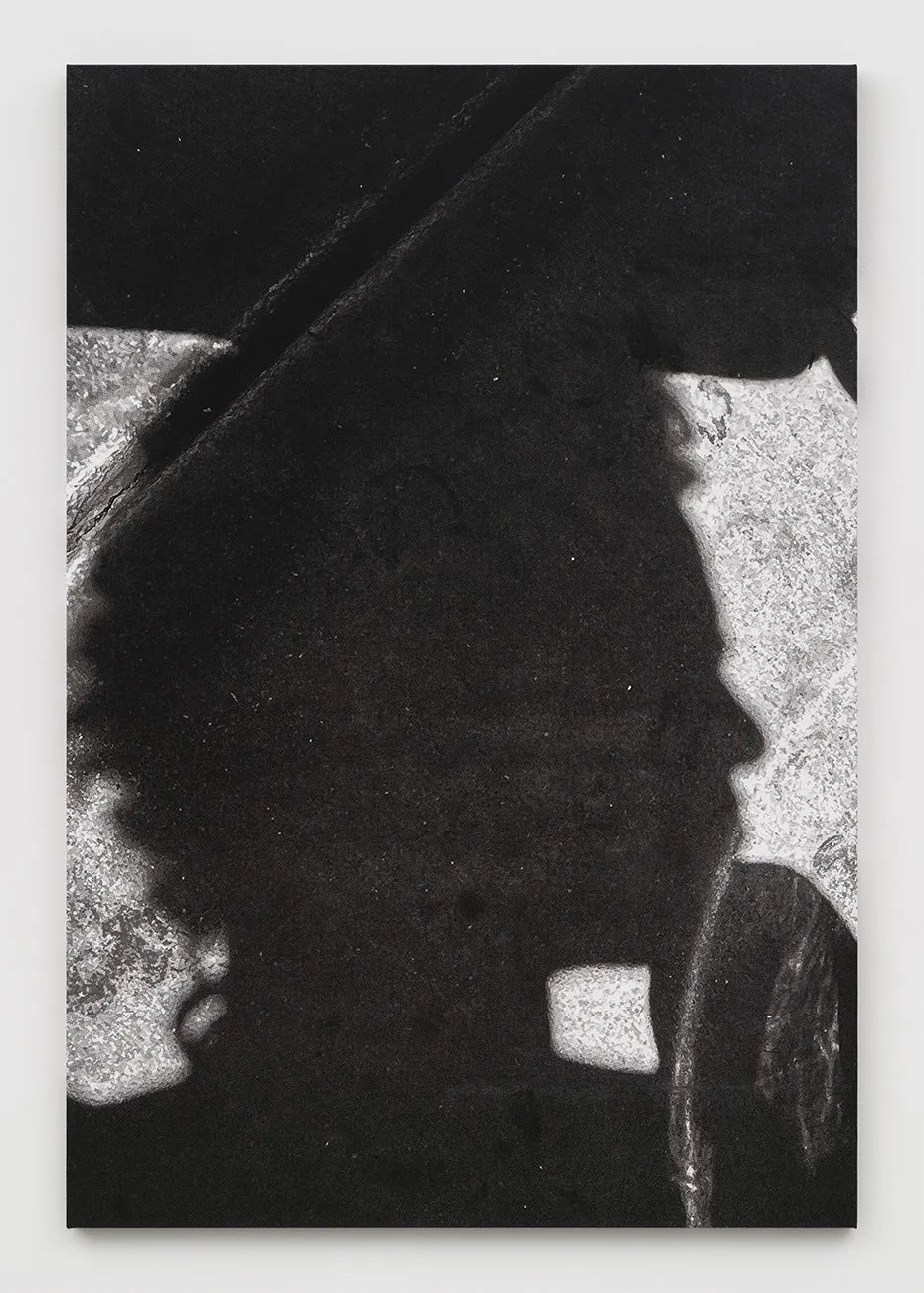 Close-up of a shadowy human profile on rough pavement with light areas cutting across.