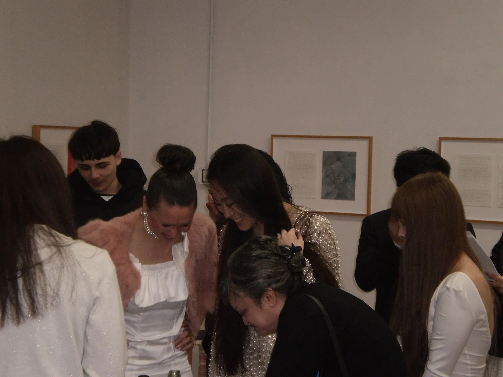 A candid, close-up shot of a group of people laughing and talking together at an indoor event.
