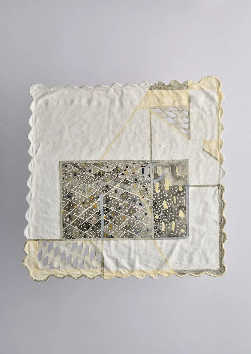 Handmade paper artwork with embedded geometric patterns, grids, and muted pigment washes on a textured white surface.