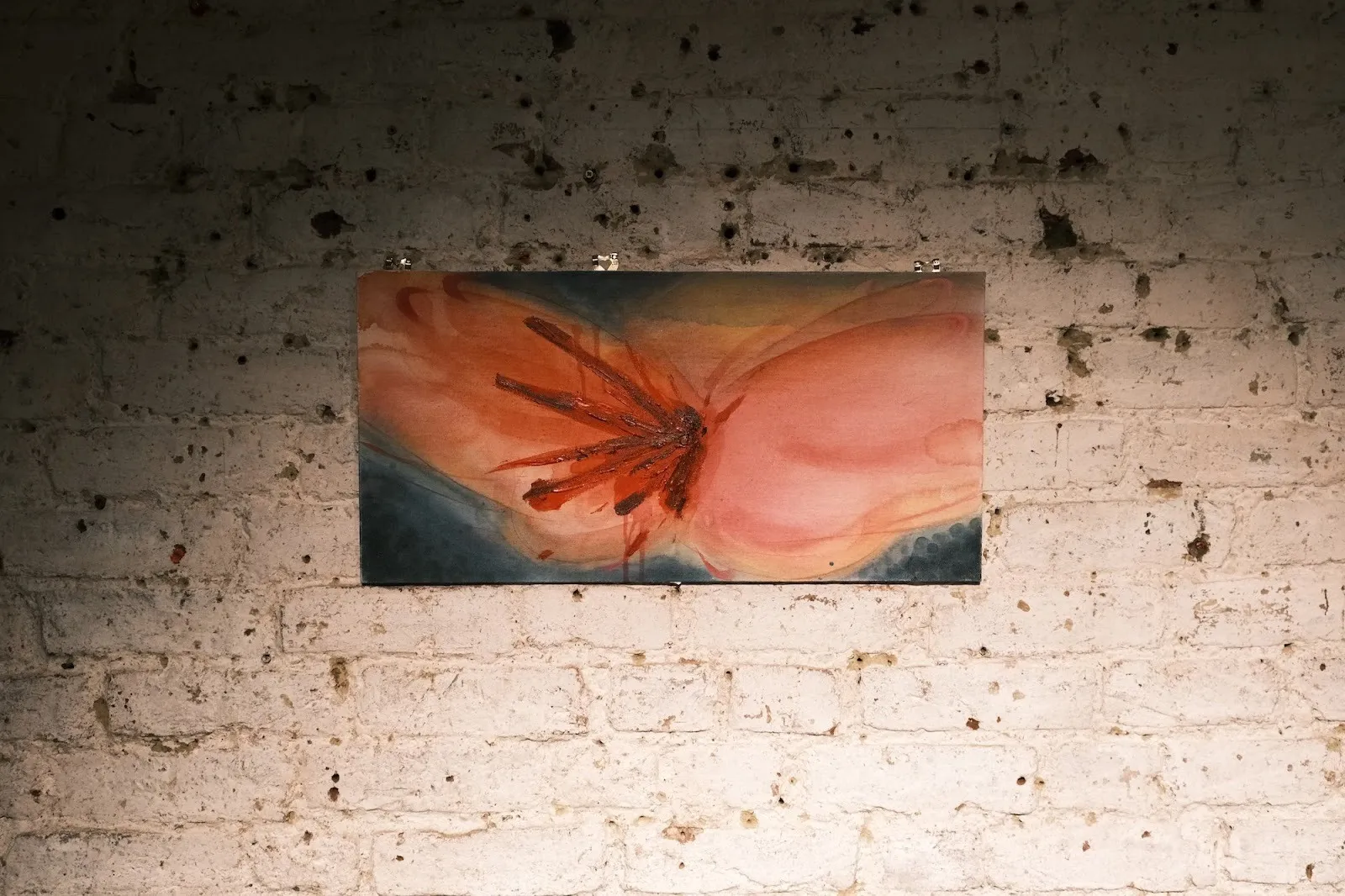 Rectangular abstract painting with soft pink, coral, and blue washes punctuated by sharp, dark red marks.