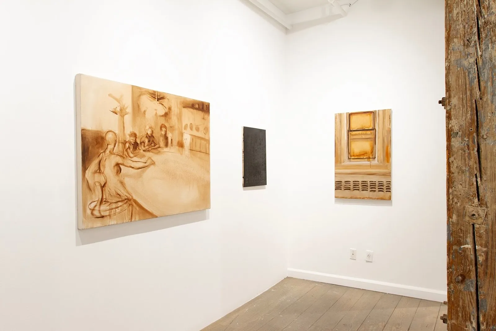 Installation view of Kimberly Heard’s works in Tender is the Night at Picture Theory, showing softly rendered, sepia-toned figurative paintings and a small dark canvas arranged in a minimalist white space.
