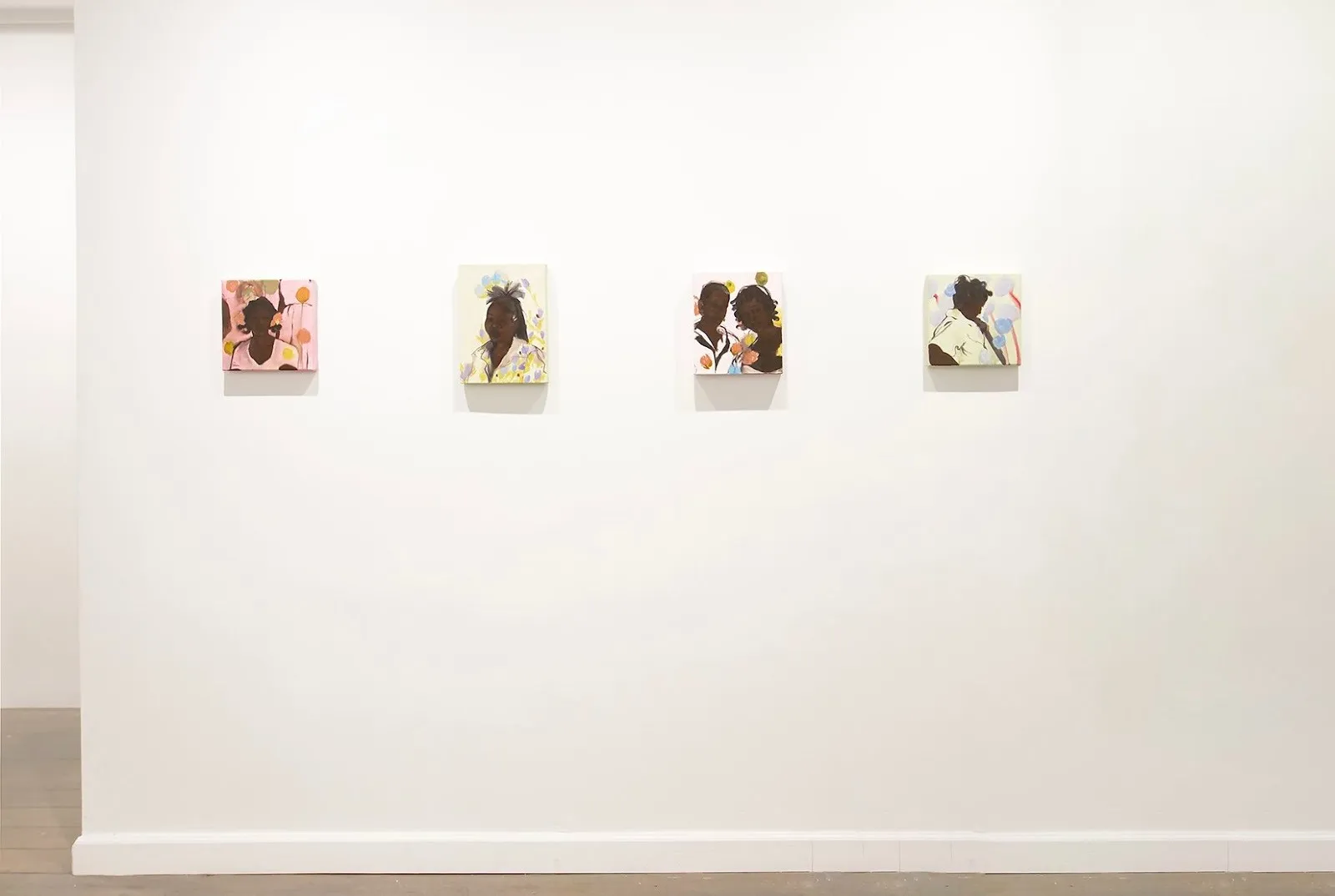 Installation view of Tuere Nicole’s works in Tender is the Night at Picture Theory, featuring four small, colorful portrait paintings evenly spaced on a white gallery wall.