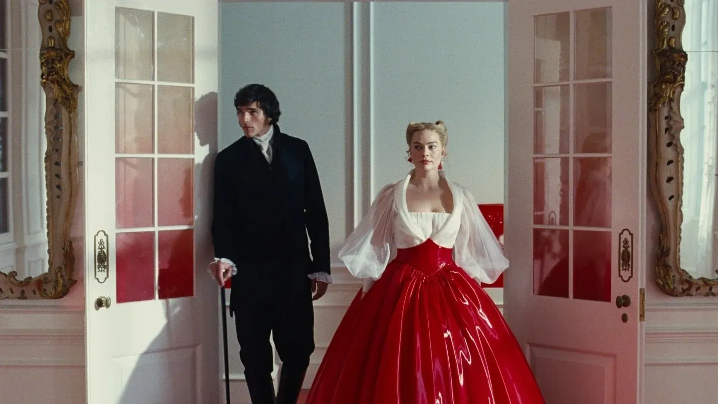 In a large, white-painted manor with large, elaborately framed mirrors, two people step through french doors. The man wears a black dress suit and white cravat, and uses a cane. The woman wears a puffy, red latex skirt and billowing white top.