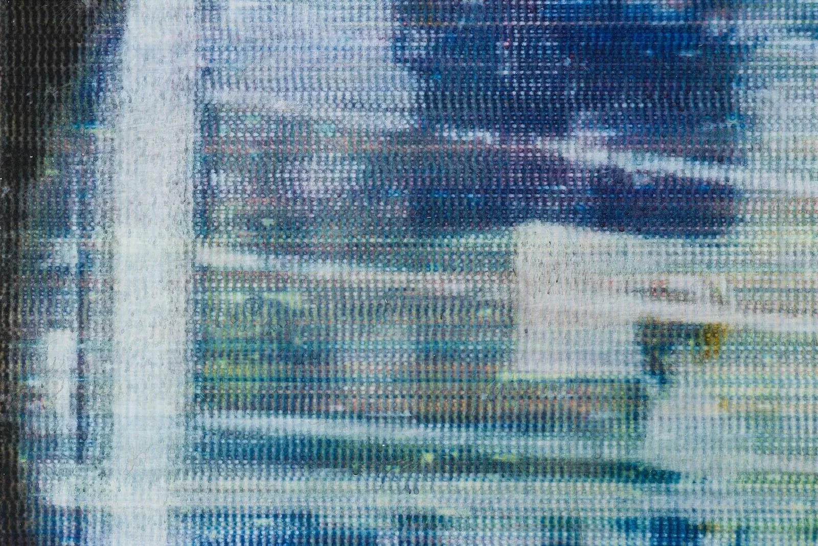 A close-up shot of a canvas features the grid of the weave colored by different blue, white, and other warm pigments. The close-up view makes the canvas appear like a pixellated screen.