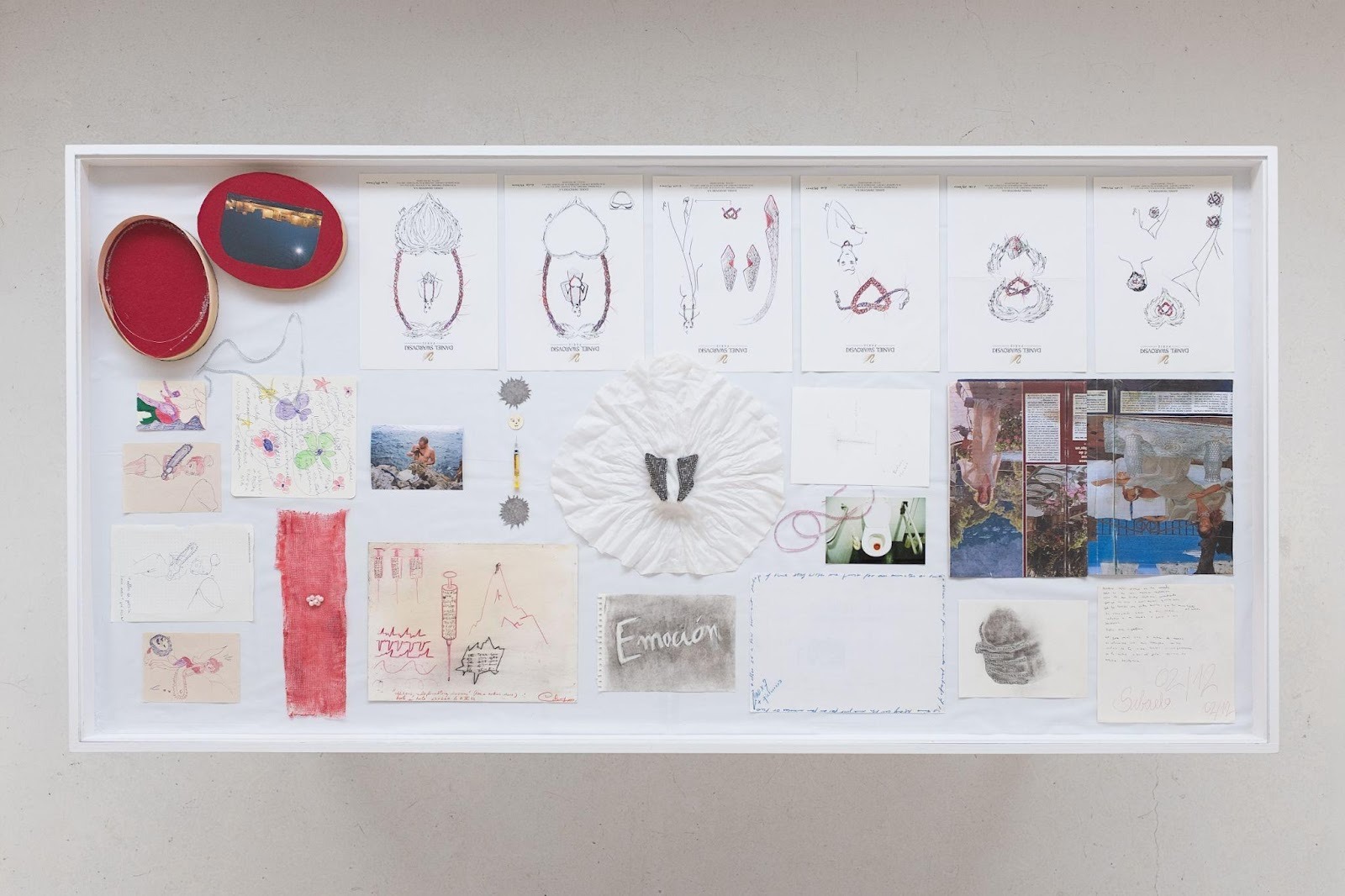 Collage on white background with red, button-like components and drawings arranged in grid format.