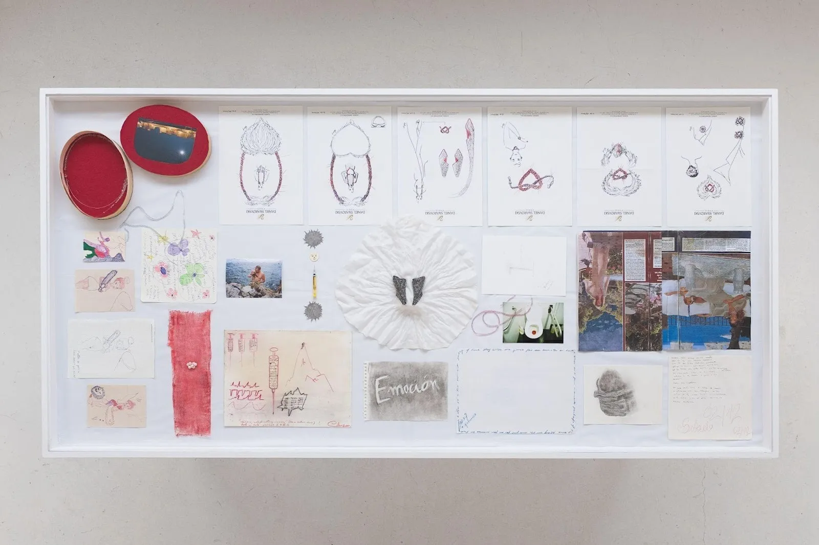 Collage on white background with red, button-like components and drawings arranged in grid format.