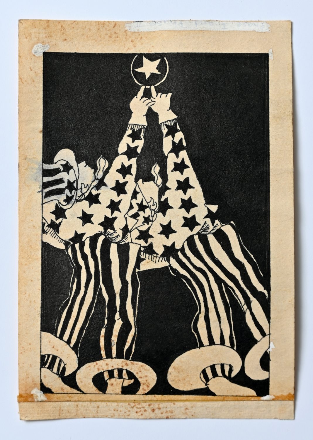Black ink drawing on white paper depicting a figure in a stars-and-stripes costume reaching upward toward a crescent moon with a star, surrounded by swirling decorative elements.