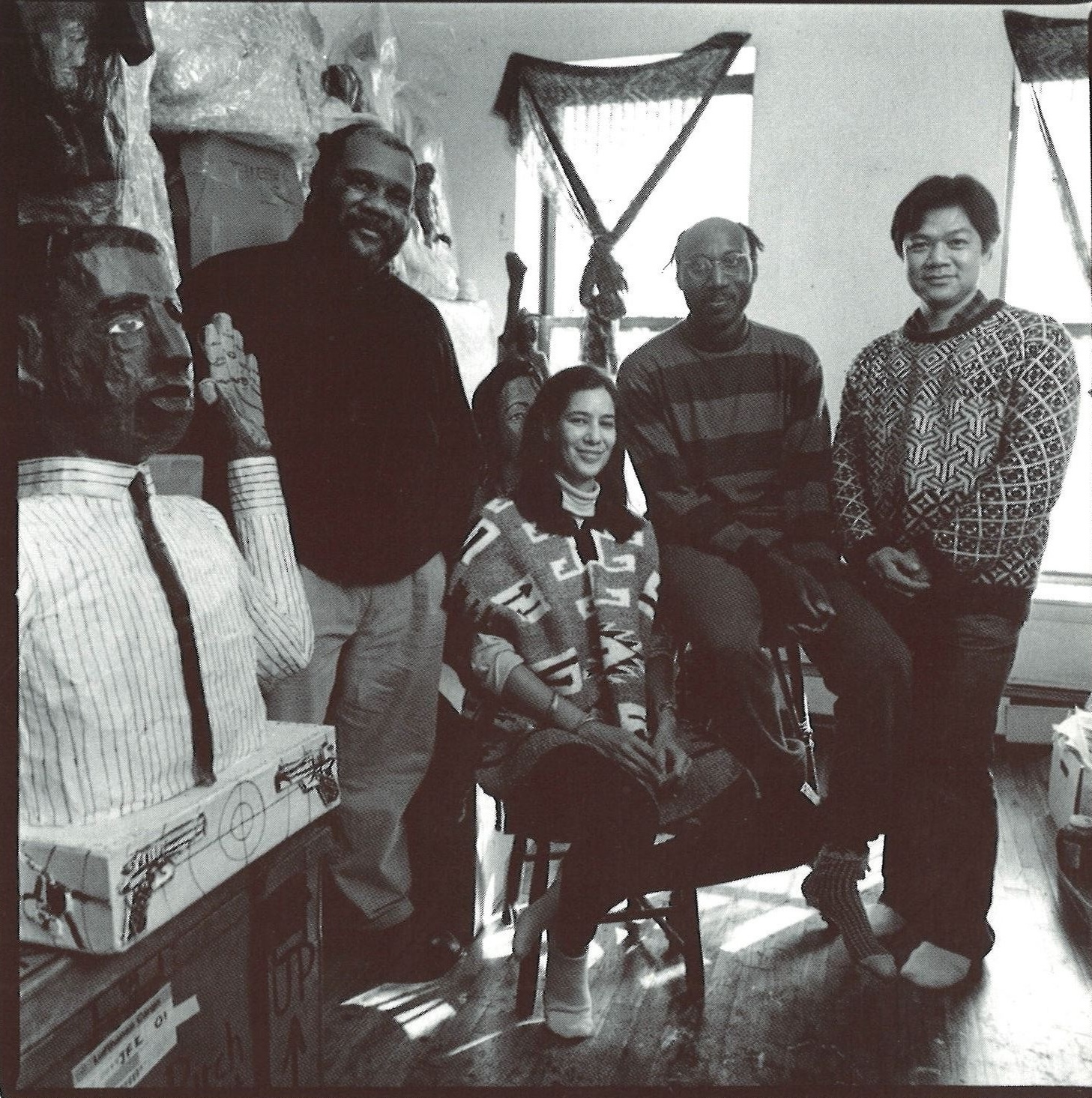 Archival group portrait of artists gathered in a studio with sculptures.