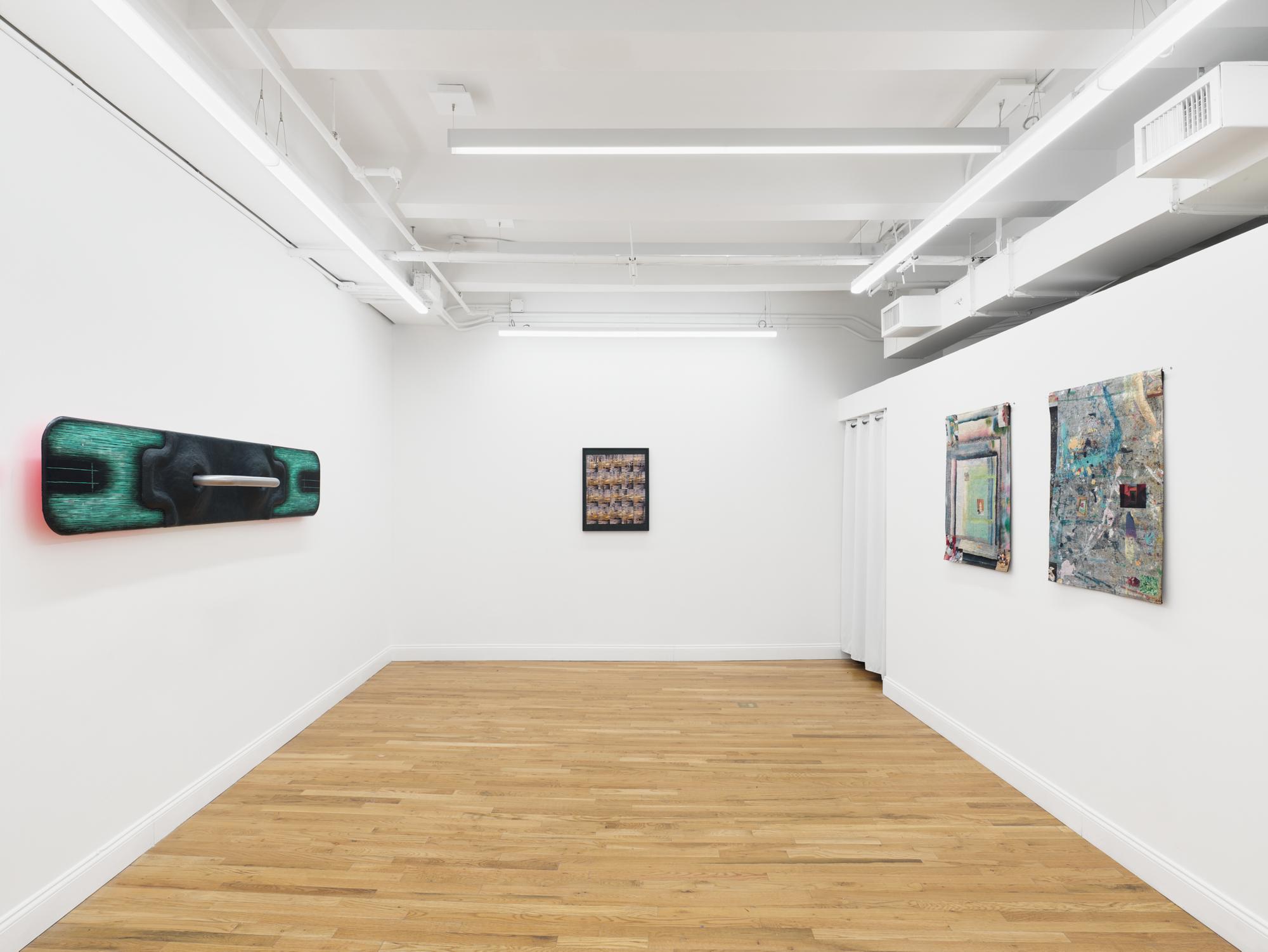 White-walled gallery with several mixed-media works displayed across three walls.