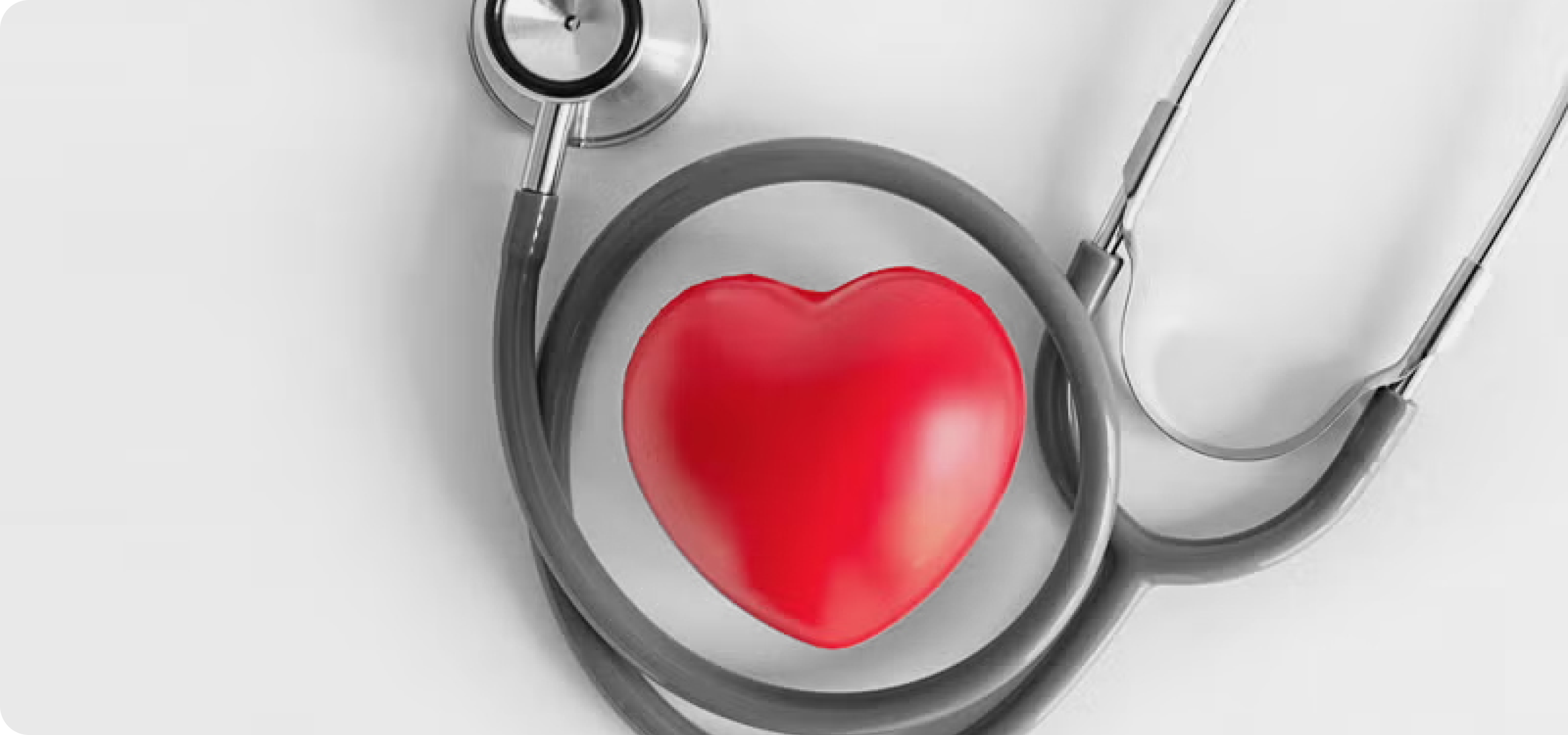 A gray stethoscope arranged in a circle around a red heart-shaped object on a white surface.