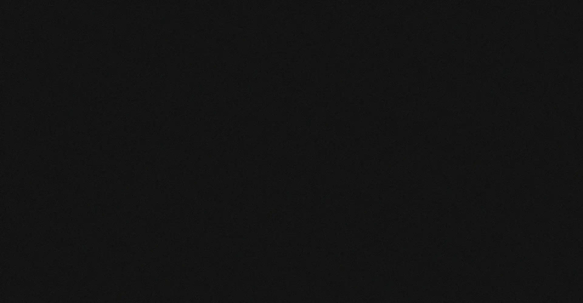 Two cheeseburgers with tomato slices and lettuce on wooden serving boards next to a small dish of fries.