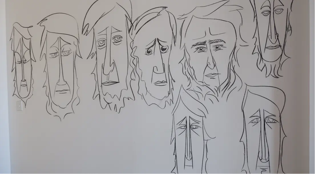 Wall art featuring eight abstract, elongated faces drawn with simple black lines on a white background.