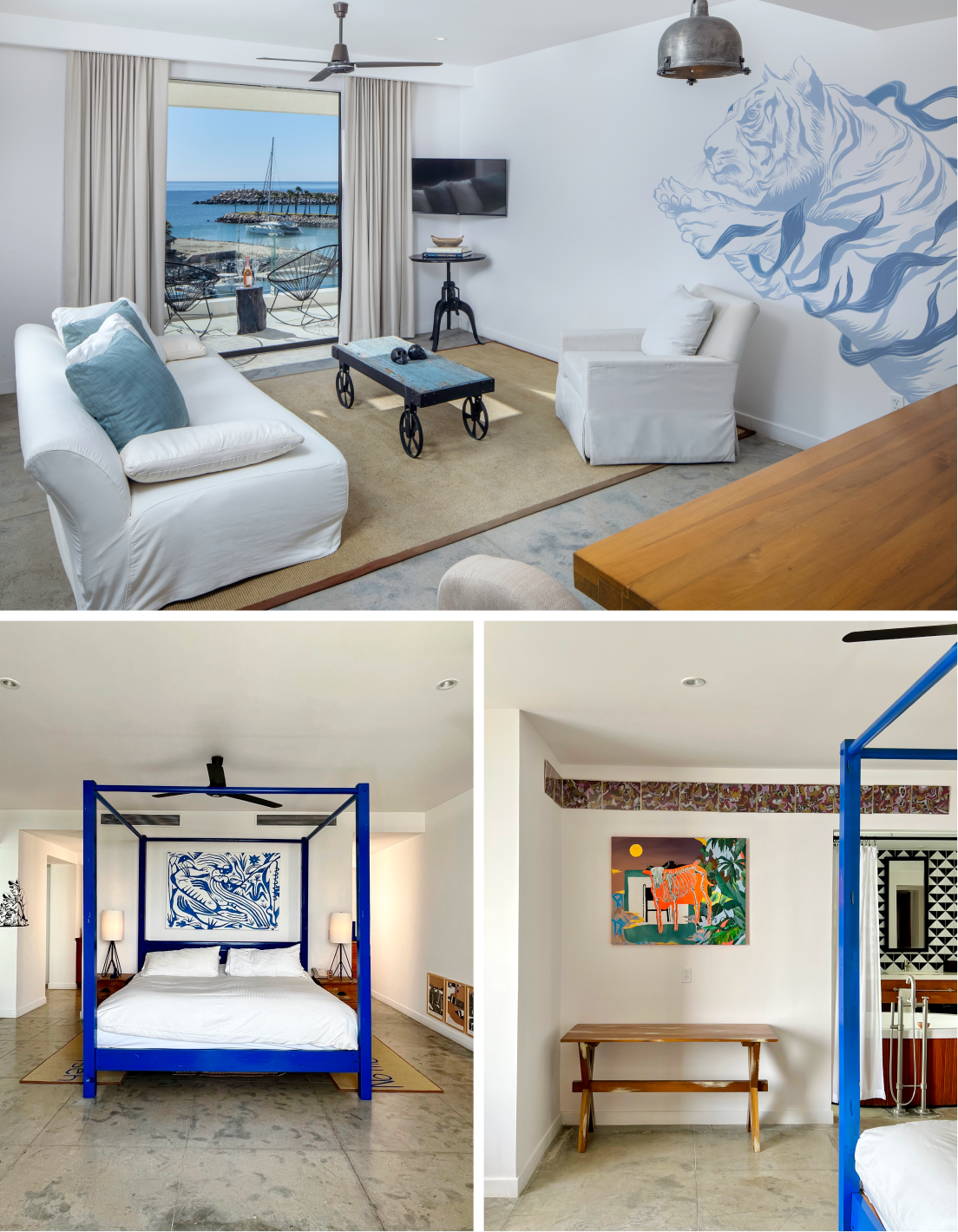 Modern one-bedroom apartment featuring a living room with white sofas and sea view balcony, a bedroom with a blue four-poster bed and tiger artwork, and a dining area with wooden bench and colorful wall art.