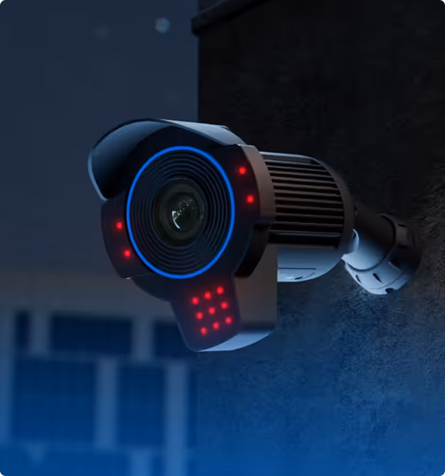 Modern security camera mounted on a dark wall at night with blue and red indicator lights.