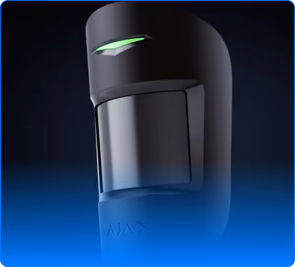 Close-up of a sleek black motion sensor device with a glowing green indicator light.