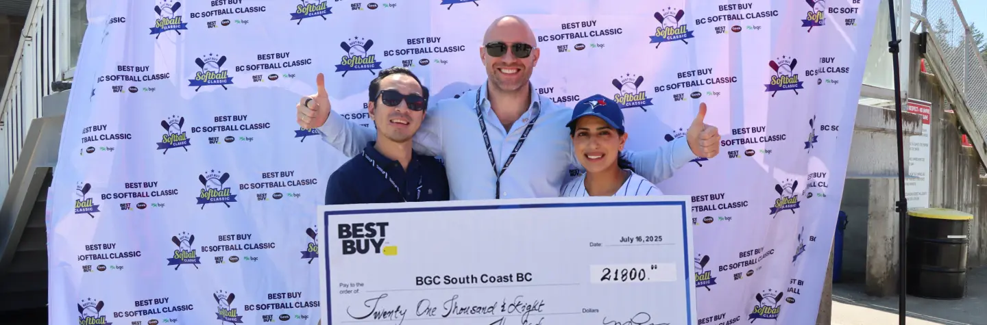 Three people smiling and holding a large Best Buy cheque for BGC South Coast BC at the Best Buy BC Softball Classic event.
