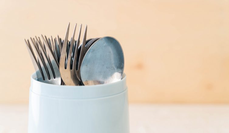 Forks and spoons organized in container to pack silverware for moving