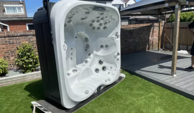 White hot tub with jets positioned in backyard ready for moving or installation