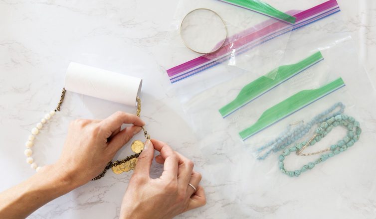 Person organizing necklaces in plastic bags for safe packing during move