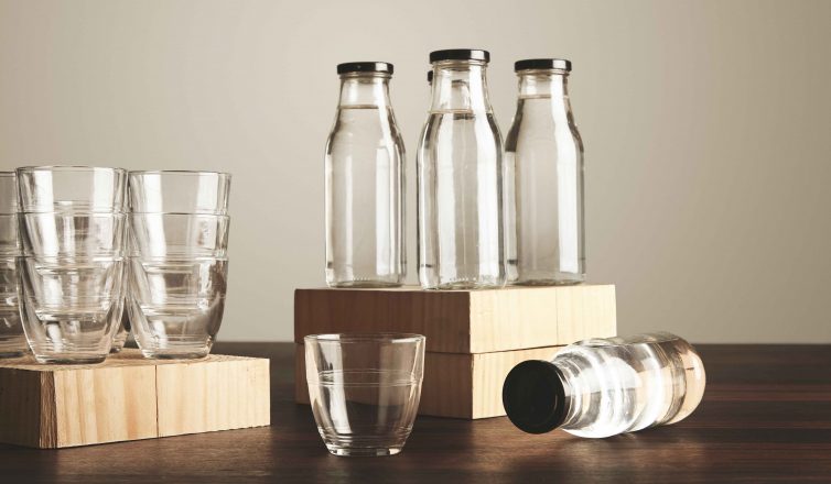 Clear drinking glasses and bottles arranged on wooden blocks ready to pack for moving