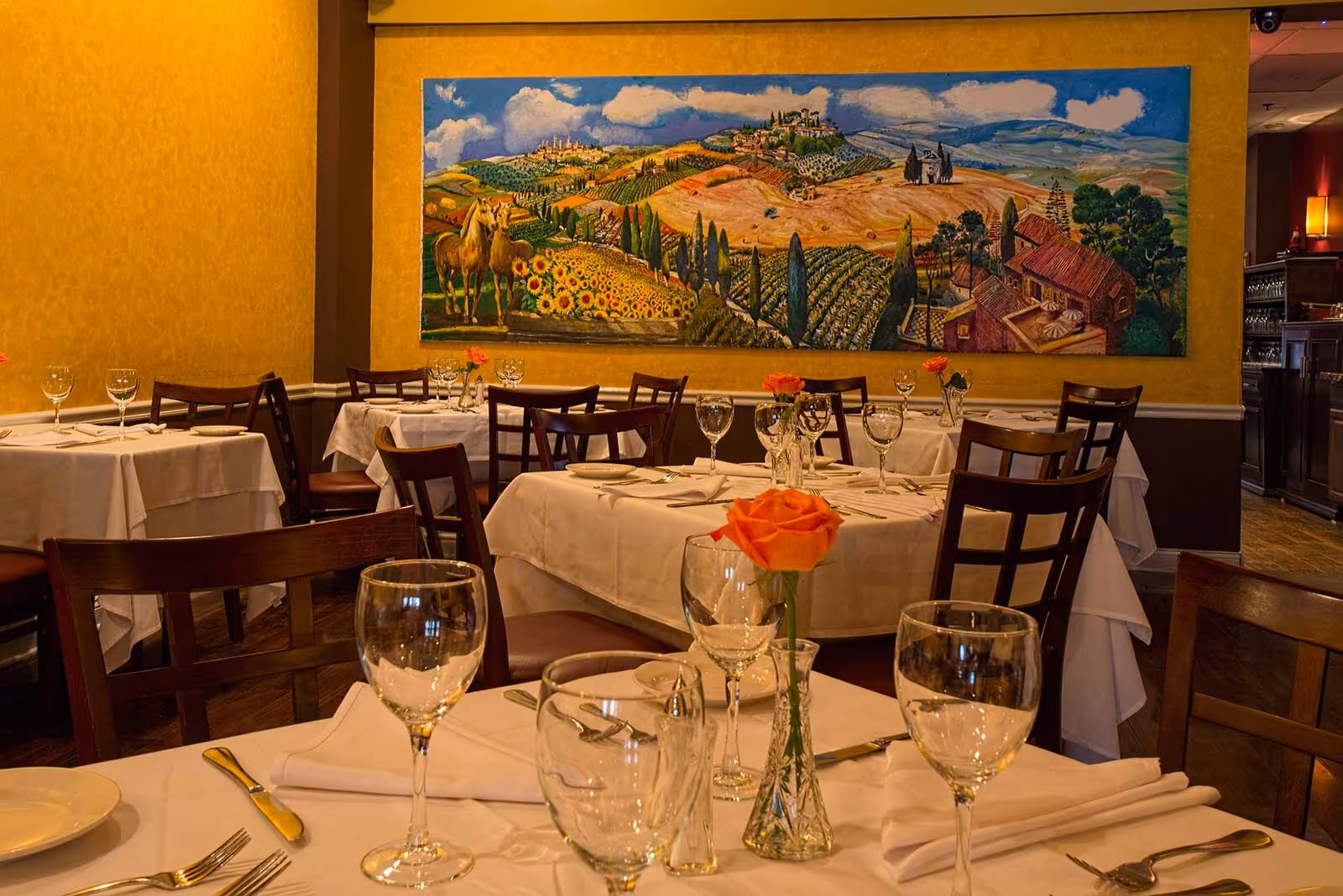 dining room with multiple tables with brown chairs and tables decorated with flowers