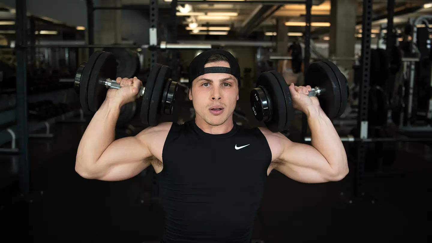 A man is lifting weights in a gym.