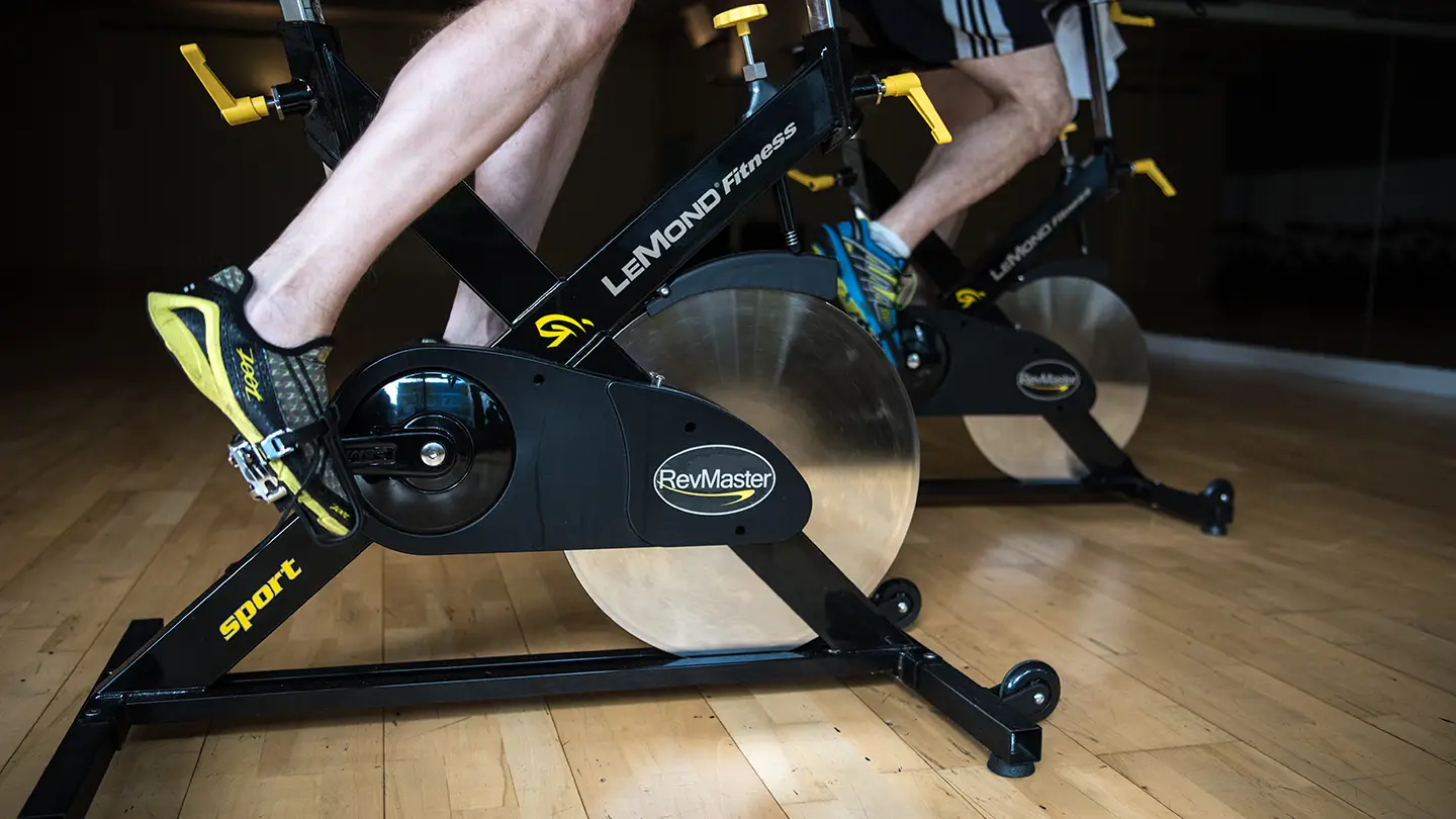 A black exercise bike with a yellow wheel.