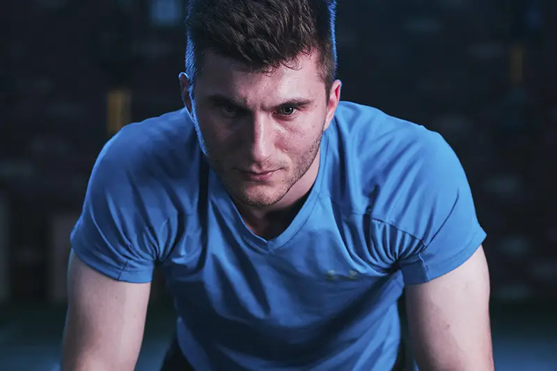 A man wearing a blue shirt and black shorts.