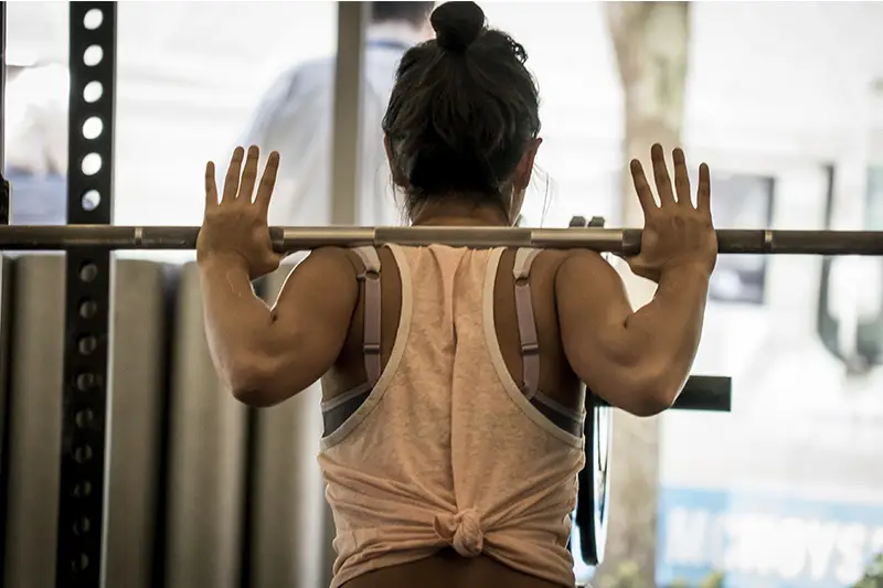 A woman is lifting weights in a gym.