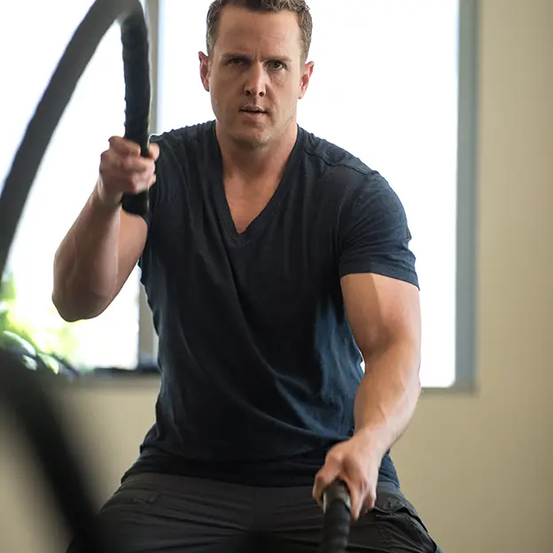 A man is holding a black and yellow rope.