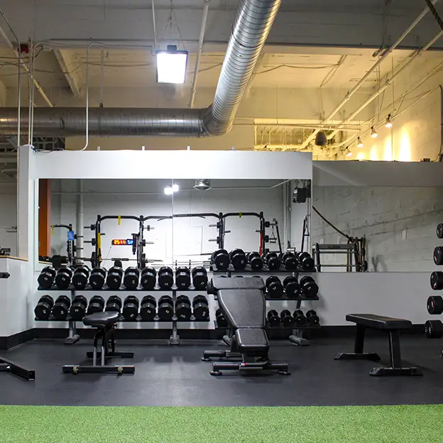 A gym with a black bench and a black and yellow sign.