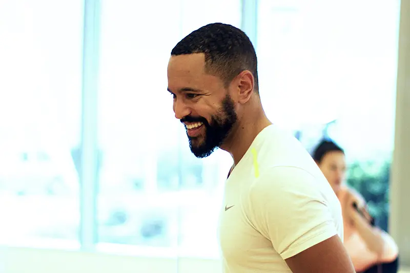 A man with a beard and a white shirt smiling.