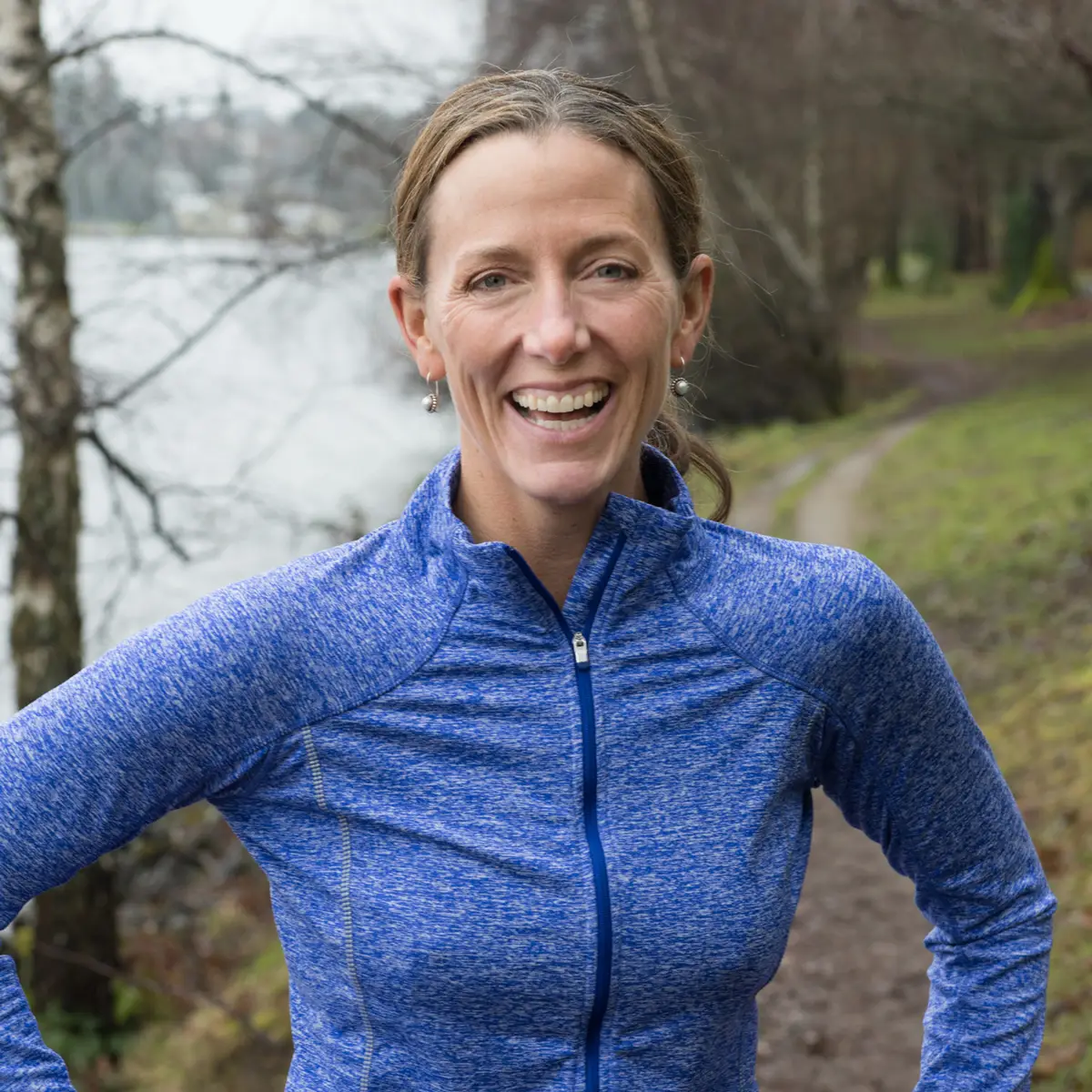 A woman wearing a blue shirt and smiling.