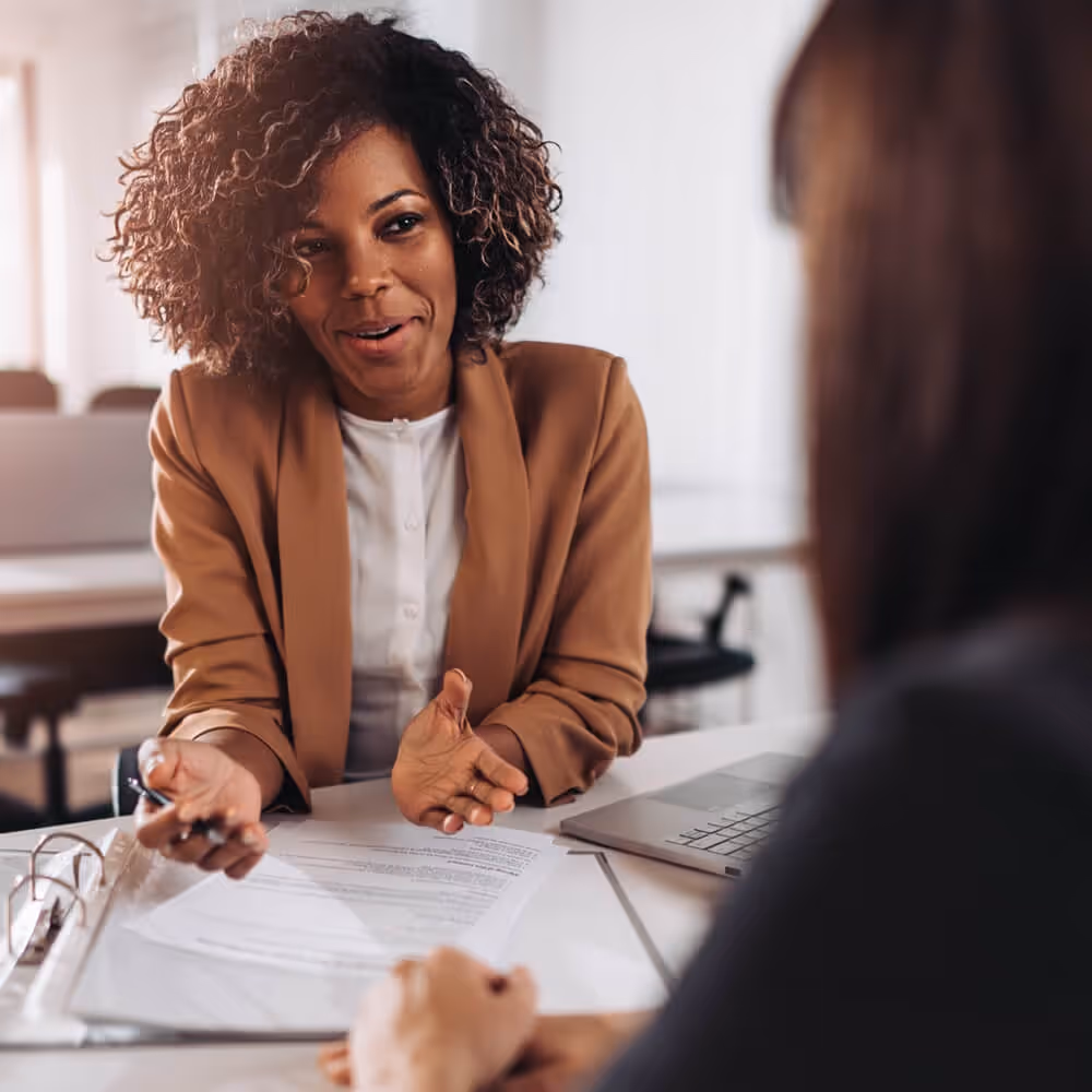 Professional discussing a debt collection matter with a client during a document review meeting.