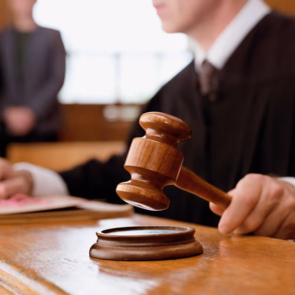 Judge holding a gavel in a courtroom during a civil court proceeding.