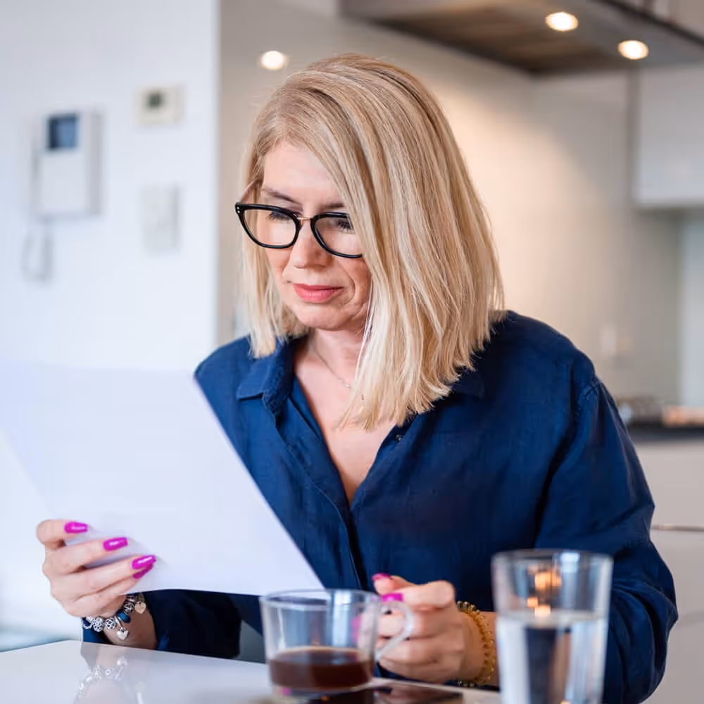 Person reviewing a contract or legal document at home.