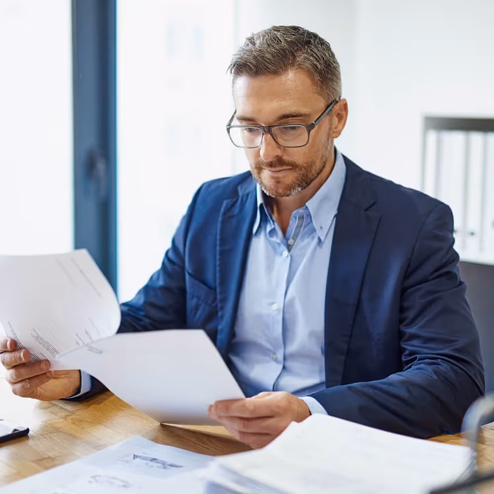 Business professional reviewing intellectual property documents at a desk.