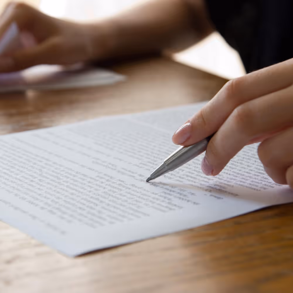 Close-up of a person reviewing a rental agreement or property document with a pen.